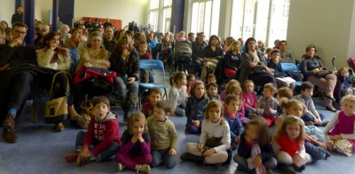 Les enfants en éveil musical prêts à chanter devant un public nombreux.